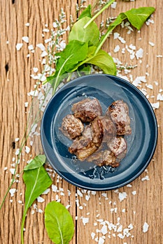 Medium Rare Fried Diced Marinated Beef on Blue Ceramic Plate on Wood Panel with Sea Salt and Vegetable Decorated