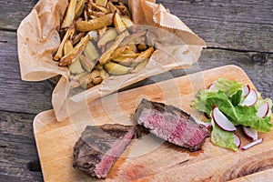 Medium rare grilled top rump steak with roasted potatoes