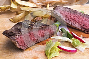Medium rare grilled top rump steak with roasted potatoes