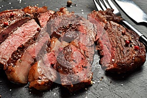 Medium Rare Ribeye steak on black stone plate