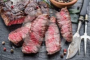 Medium rare Ribeye steak with herbs on graphite board