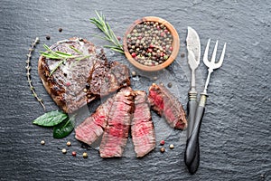 Medium rare Ribeye steak with herbs on graphite board
