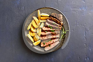 Medium rare roast beef with potato wedges