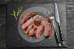 Medium Ribeye steak on black stone plate photo