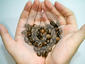 Medium roasted coffee beans, heart shape, on both palms