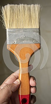 Medium seize unused new wooden wall painting brush hold on hand at home in Dhaka, Bangladesh.