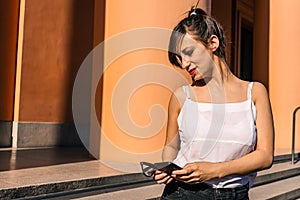 Medium shot of an attractive Latin woman reviewing and answering the messages received on her cell phone. Technology,