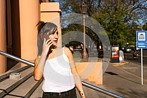 Medium shot of an attractive Latina woman talking on the cell phone. Technology, communications concept