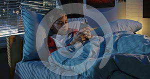 Boy text messaging while lying in bed