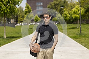 Medium Shot of Casually Dressed Man With a Basketball and Gym Ba