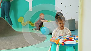 medium shot of a cute girl playing in kindergarten, other kids in the background, activities for kids