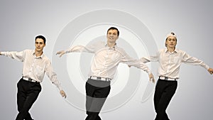 Three smiling guys in white shirts doing synch dance routine loo