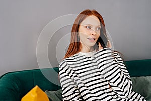 Medium shot of happy young woman with broken arm wrapped in gypsum bandage talking on smartphone with friends during