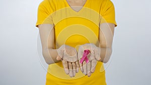 Medium shot of Indian woman with a pink breast cancer awareness ribbon in hands - women healthcare concept