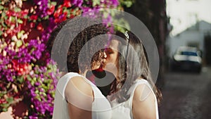 Medium shot of lesbian couple hugging and kissing before wedding