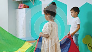 medium shot of little kids playing with their teacher in the playroom, nursery