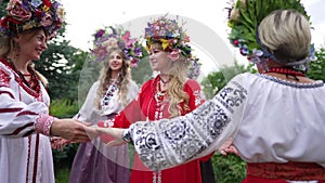 Medium shot portrait of smiling Ukrainian woman standing outdoors admiring young ladies walking around. Confident