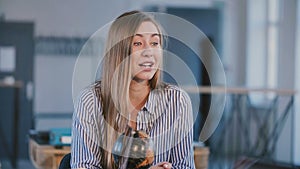 Medium shot portrait of young happy beautiful successful Caucasian businesswoman talking behind office table on meeting.