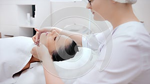 Medium shot professional beauty specialist making contouring massage of chin line side view
