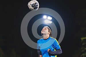 medium shot of a school-age soccer player girl throwing a ball up in the air, sport and girls concept