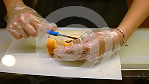 Medium Shot Waitress hands in transparent glowes preparing and serving sandwichon paper