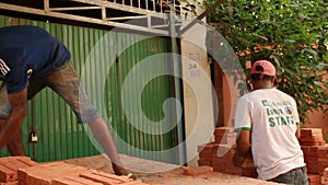 Medium shot of workers unloading and stacking bricks