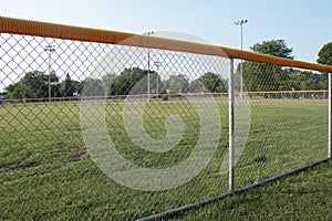 medium wide shot of non professional baseball outfield shot through foul line