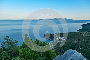 Medveja - A small metal cross on a rock with a panoramic view of the shore