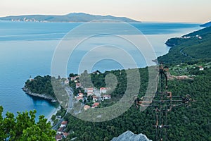 Medveja - A small metal cross on a rock with a panoramic view of the shore