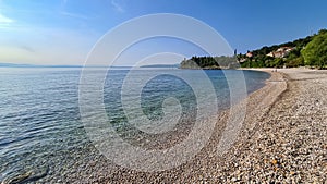 Medveja - A stony beach along the shore of Medveja in Croatia. The Mediterranean Sea is calm and clear