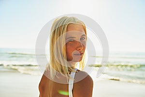 Meet me where the sky touches the sea. Cropped portrait of an attractive young female looking over her shoulder on the