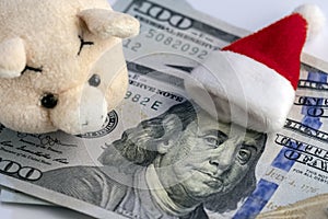 Meet the New Year without financial debts. The Santa`s hat lies on Franklin`s head on hundred dollars, a pink soft toy pig, and