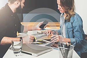 Meet one-on-one. Business meeting. Teamwork. Businessman and businesswoman sitting at table. Man using smartphone