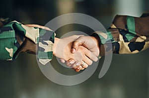 Meeting, army or shaking hands for partnership, teamwork or deal in war, agreement or unity together. Closeup, soldiers