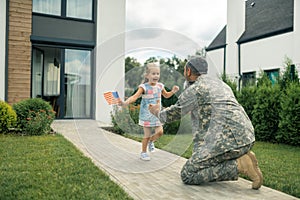 Military servant meeting his cute lovely girl near the house photo