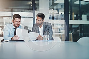 Meeting, documents and businessmen in discussion in the office boardroom planning a corporate strategy. Brainstorming