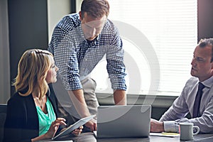 Meeting with like minded go getters. a group of colleagues having a meeting in the boardroom at work.