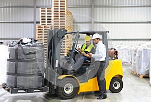 Meeting of the manager and worker in the warehouse - forklift an