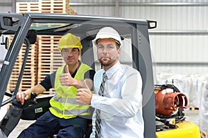 meeting of the manager and worker in the warehouse - forklift and interior of the industrial building