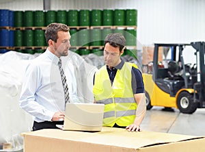 meeting of the manager and worker in the warehouse - forklift and interior of the industrial building