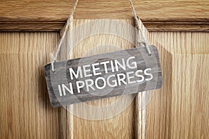 Meeting in progress sign on office door