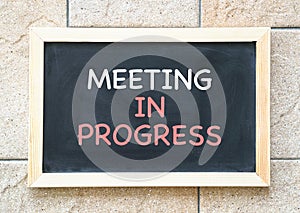 Meeting in progress, words printed on a blackboard