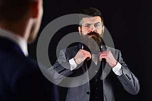 Meeting of reputable businessmen, black background. Man with beard on serious face, ties bow tie before meeting