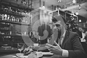 Meeting at the restaurant. Bearded man in restaurant with companion. Business on go and communication. Confident bar