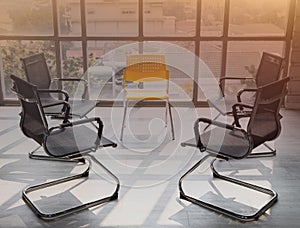 Meeting room with black chairs put in a circle prepared for office workers for brainstorming meetings. Empty chair there was no