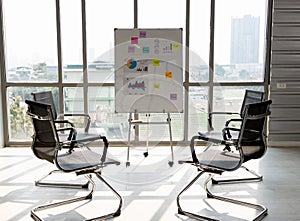 Meeting room with black chairs put in a circle prepared for office workers for brainstorming meetings. Empty chair there was no