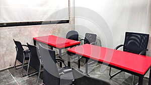 Meeting Room in Office with Two Red Tables, Black Chairs and White Board