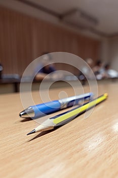 Meeting room with pencil and pen foreground shallow focus portrait