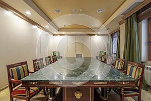 Meeting room with a wooden table and green marble with chairs