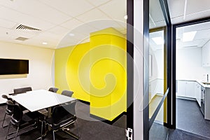 Meeting room with yellow walls hallway to kitchen